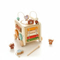 Wooden toy with multiple levels and colorful components on a light surface.