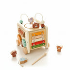 Wooden toy with multiple levels and colorful components on a light surface.