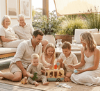 Family of six with children and grandparents sitting outdoors on a patio.