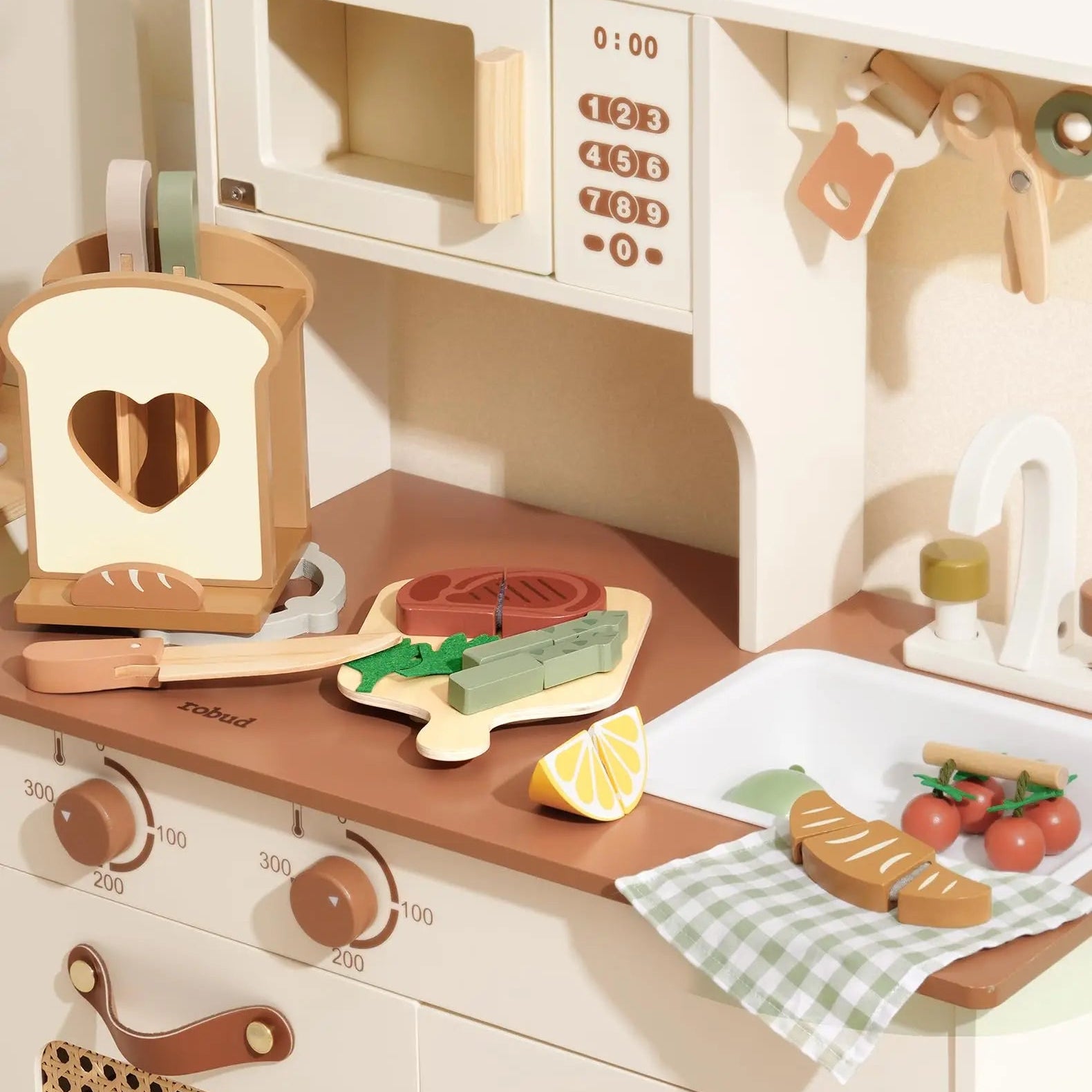 Wooden toy kitchen set with various utensils and appliances on a white background.