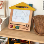 Wooden children's drawing board with colorful buttons on a wooden surface.