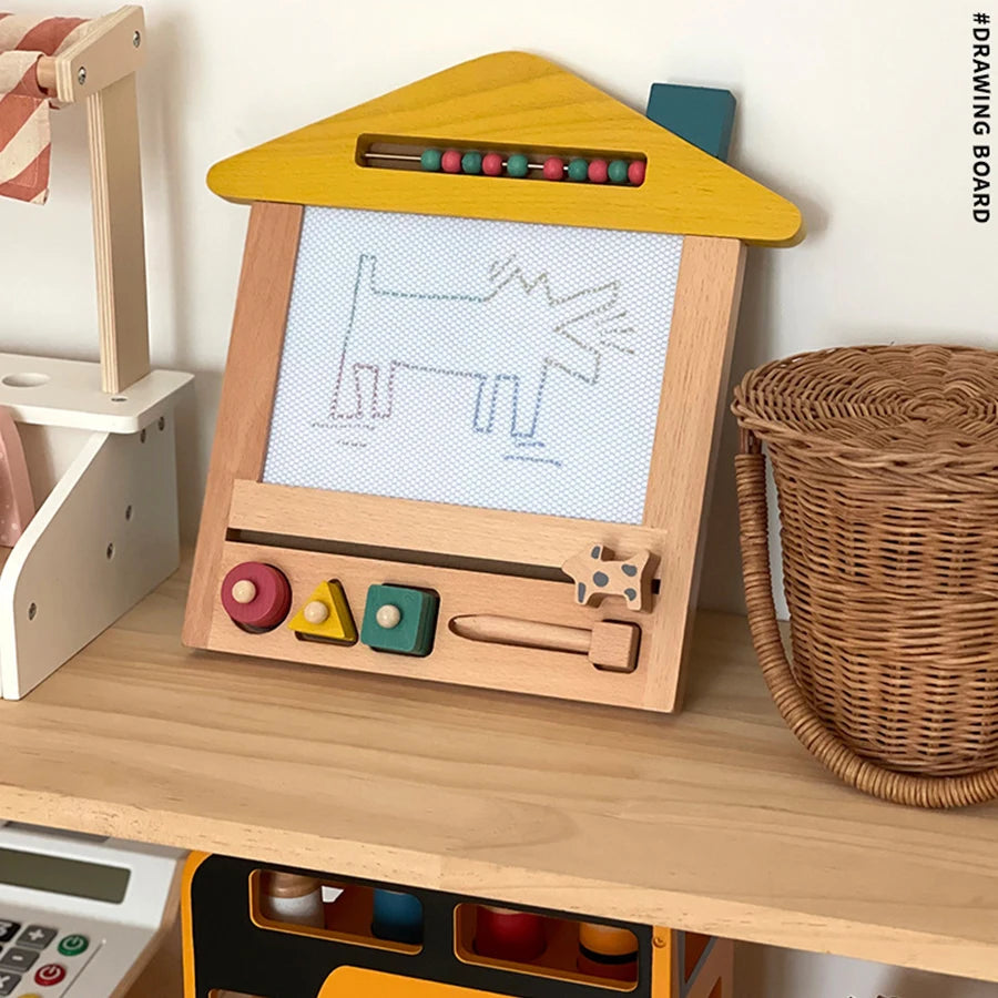 Wooden children's drawing board with colorful buttons on a wooden surface.