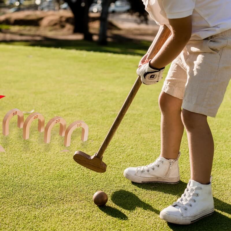 Wonder Kiiids Children’s Wooden Simulation  Golf Set – Eco-Friendly Mini Golf for Kids   playing mini golf on a green course with a wooden club and ball.