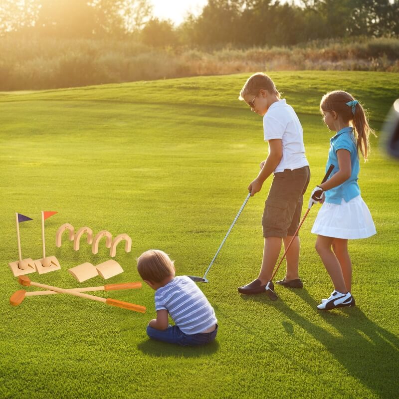 Children playing golf on a grassy field with flags and clubs. Wonder Kiiids