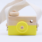 Wooden toy camera with a yellow front on a white background