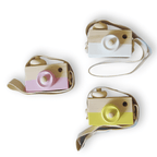 Three colorful camera-shaped toys with straps on a white background