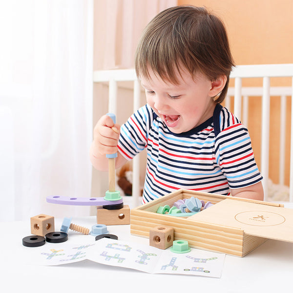 Child playing with  wonder kiiids wooden toys on a table